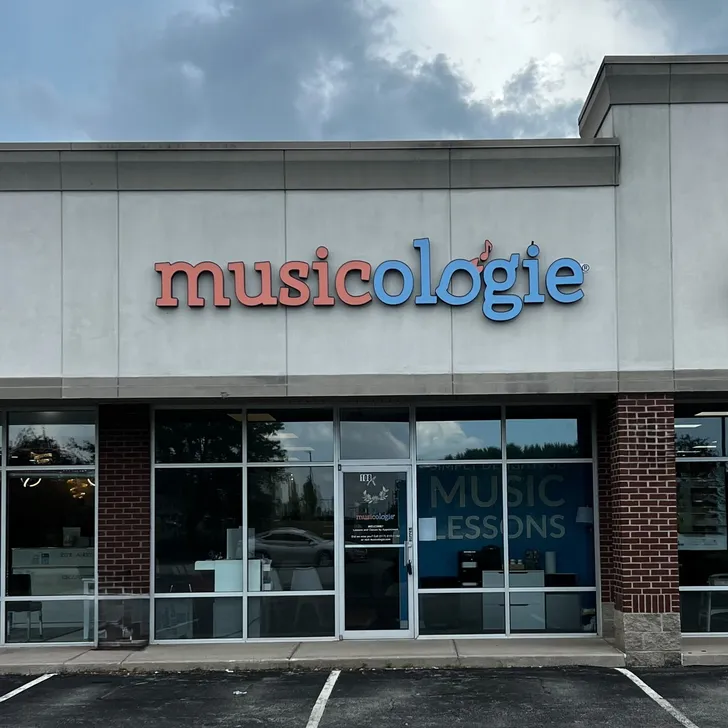 Girl playing piano in a piano lesson with her teacher sitting beside her