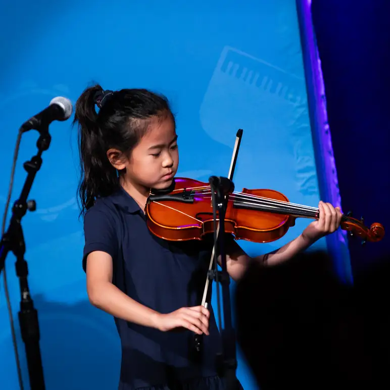 Girl Playing the Violin on Stage