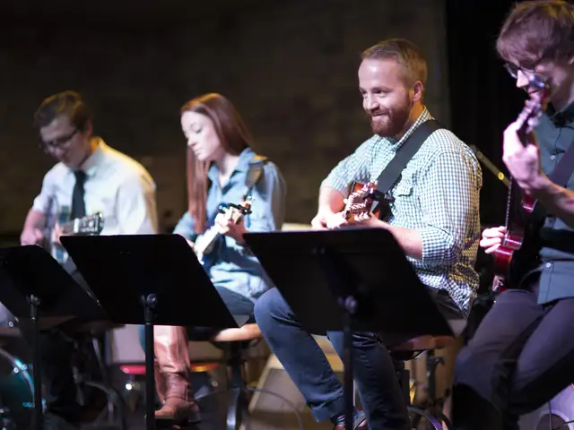 Four guitar players performing together on stage