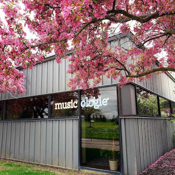 Girl playing piano in a piano lesson with her teacher sitting beside her