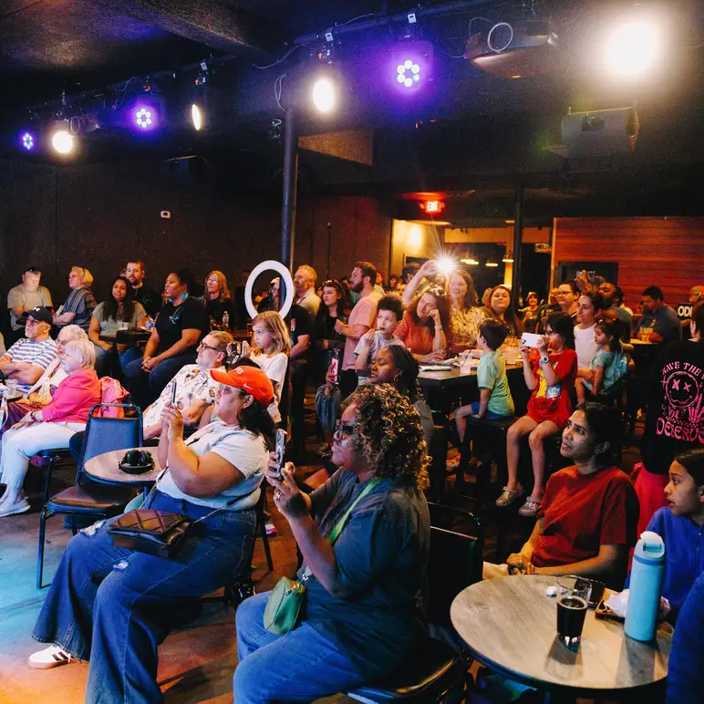 A crowd watches performers at Musicologie concert at a local venue.