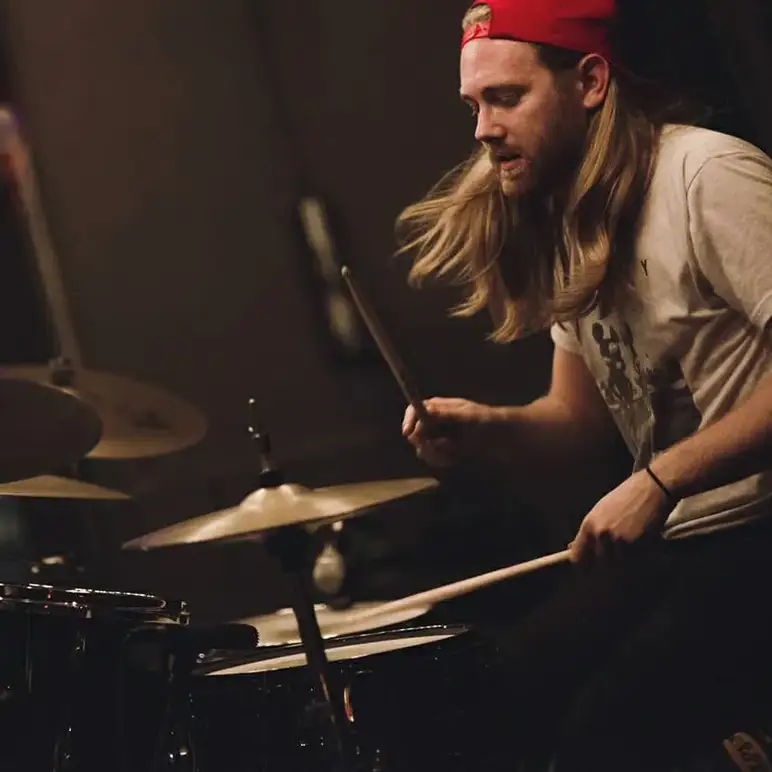 A Musicologie teacher performing on their drum set