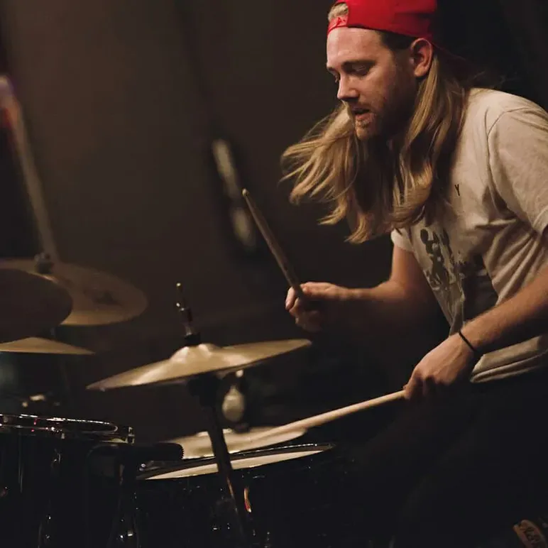 A Musicologie teacher performing on their drum set