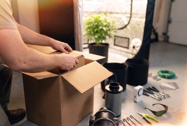 Hands unboxing cannabis growing supplies