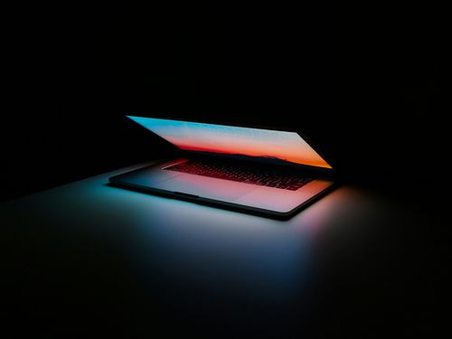 Laptop opening with colorful light reflecting