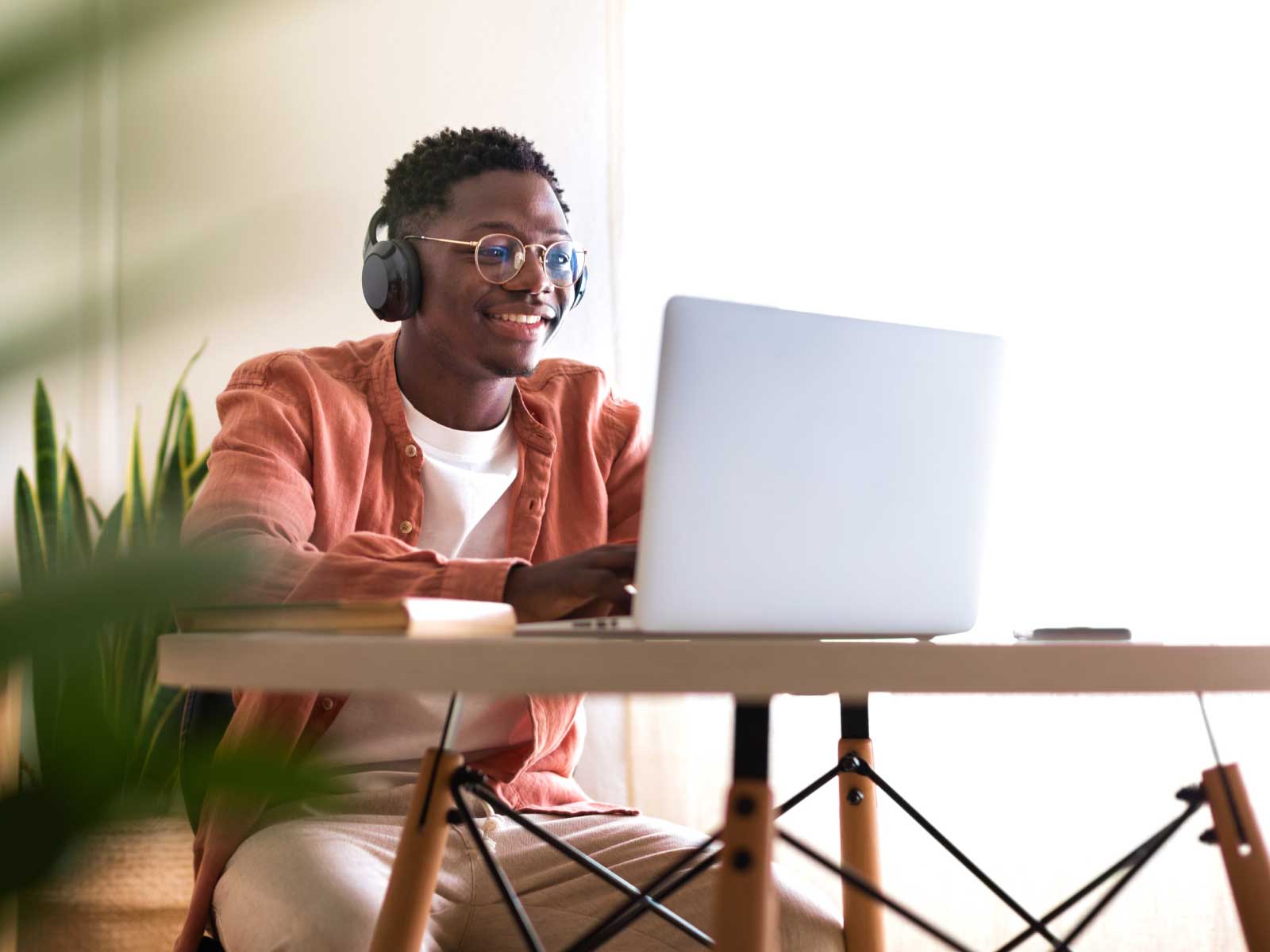 person wearing headphones working on a laptop
