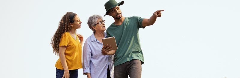 Man with tablet helping 2 women