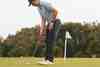 Golfer setting up to putt beside the flagstick on the green