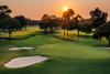 Lush parkland golf course with tree-lined fairways and manicured turf