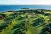 Alcanada Golf Club, Mallorca - the famous par-three island-green hole with the Alcanada lighthouse and Alcudia Bay beyond
