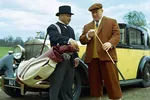 A scene from Goldfinger showing Auric Goldfinger preparing for his iconic golf match with James Bond, with his caddie Oddjob by his side at Stoke Park Golf Club in England.