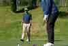 Golfer playing a chip shot from grass beside the green