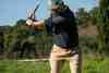 Golfer completing a driver follow-through with the club high behind him