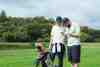 Two golfers in matching white shirts studying a phone beside their bags on the fairway