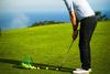 Golfer chipping to a clifftop practice green above the sea