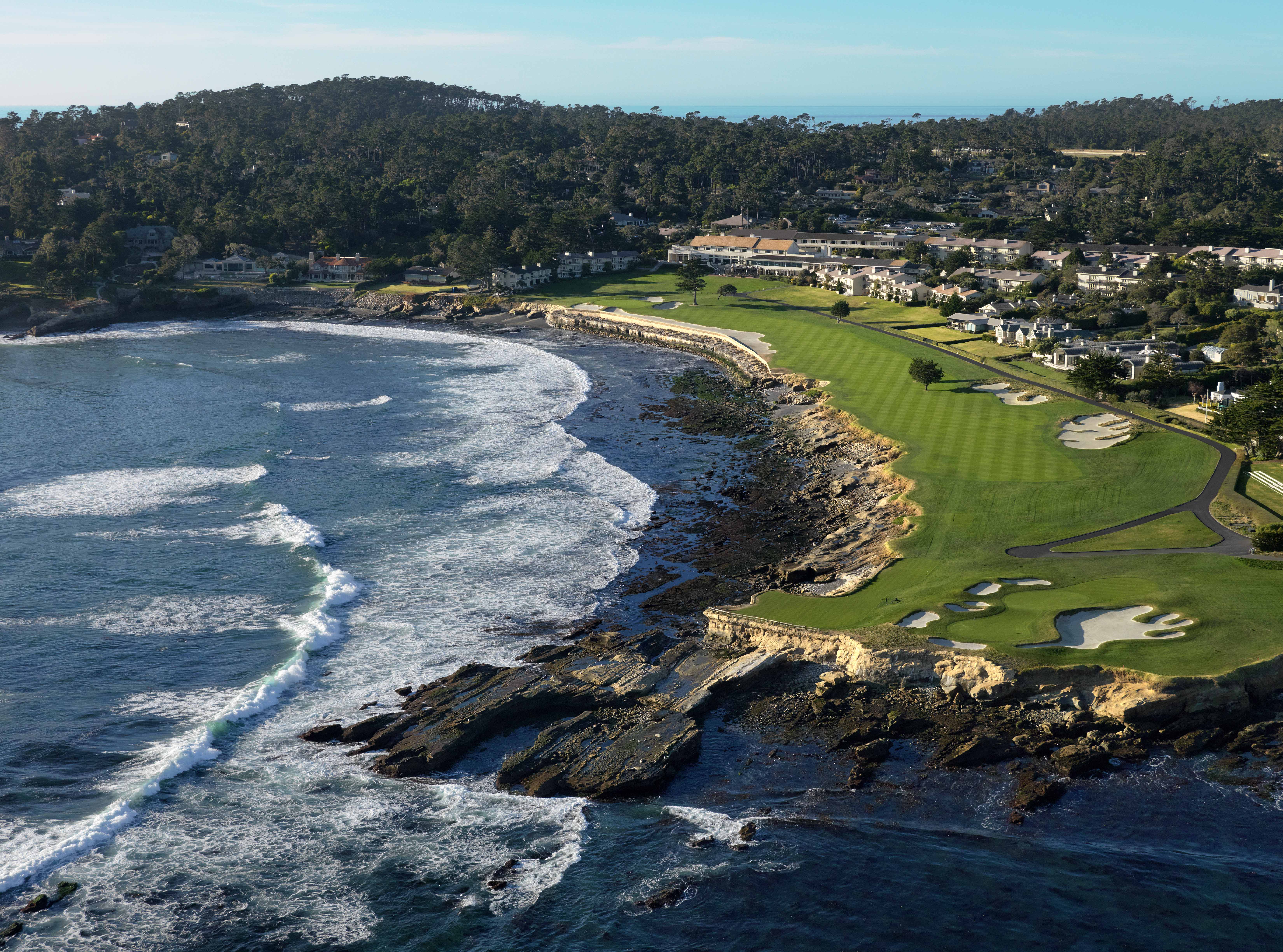 Aerial view of the 18th hole at Pebble Beach Golf Links along the rocky Pacific coastline