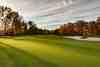 Fairway and greenside bunker framed by trees in full autumn colour