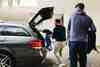 Two golfers loading their bags into a car boot at the start of a golf trip