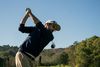 Golfer at the top of the backswing on the fairway
