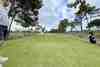 Golfers on the tee of a pine-lined hole under a big cloudy sky (courses)