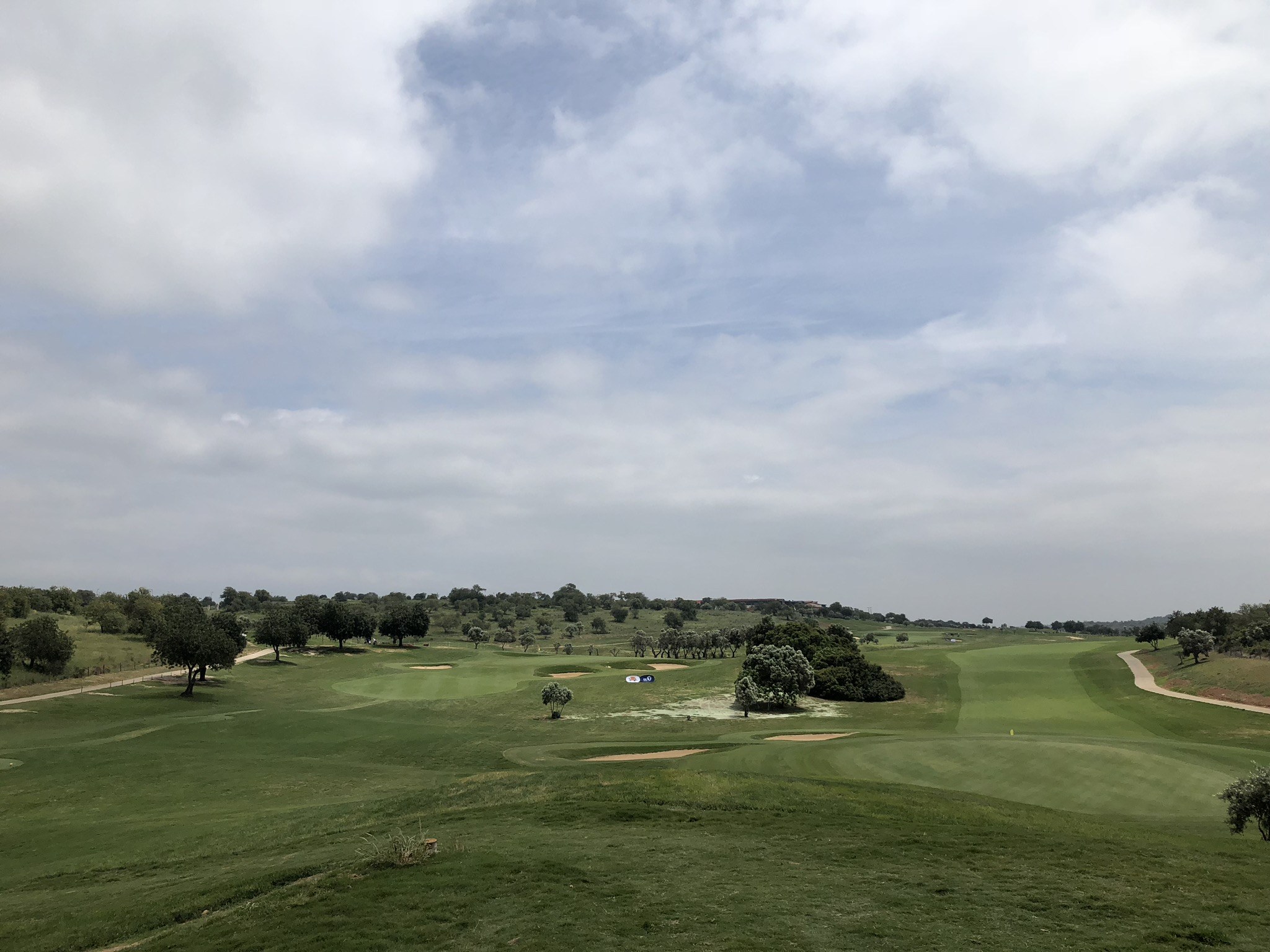 Wide open fairway and green under a clear blue sky