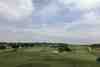 Wide open fairway and green under a clear blue sky