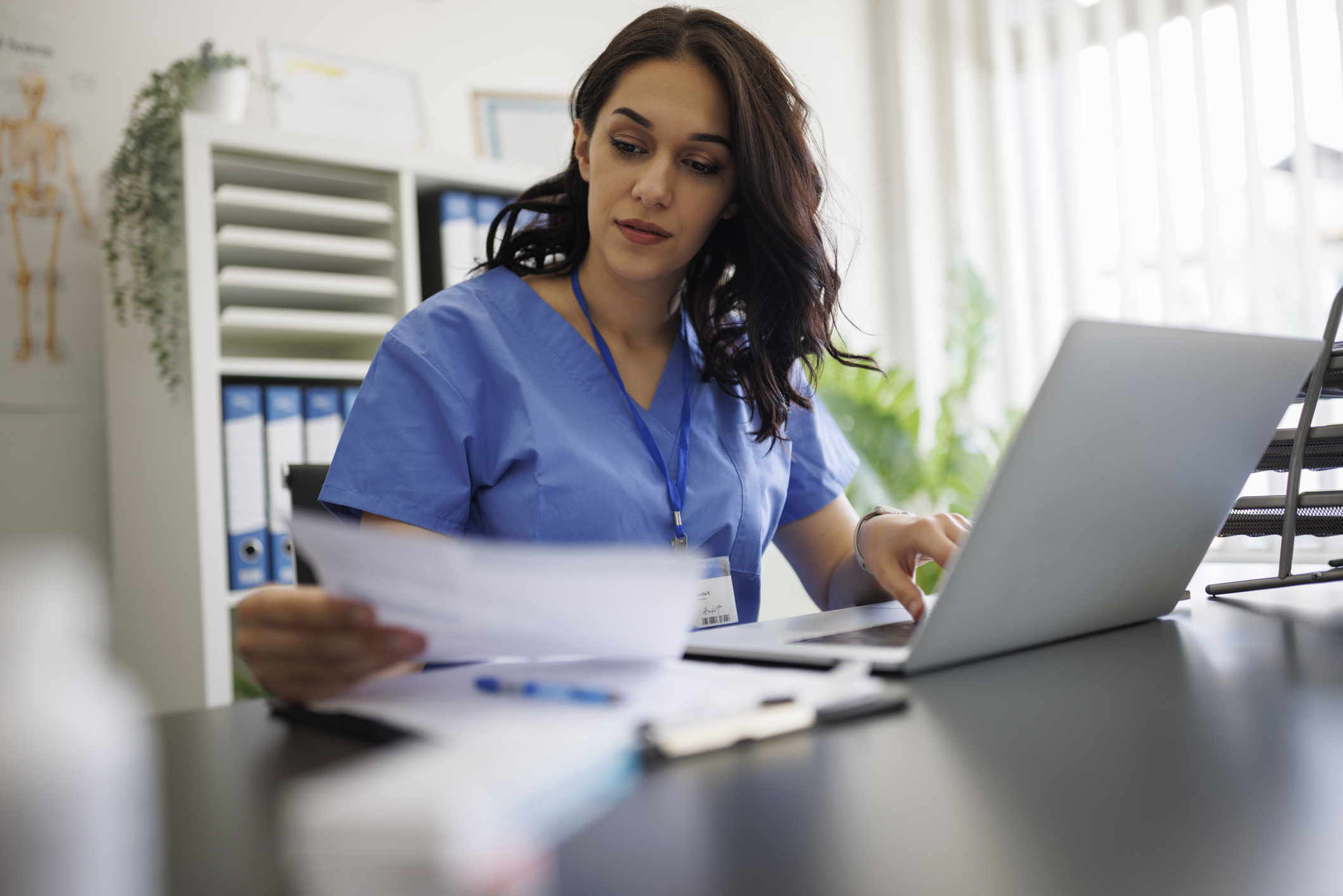 Advanced practice provider looking at paperwork while sitting at a desk