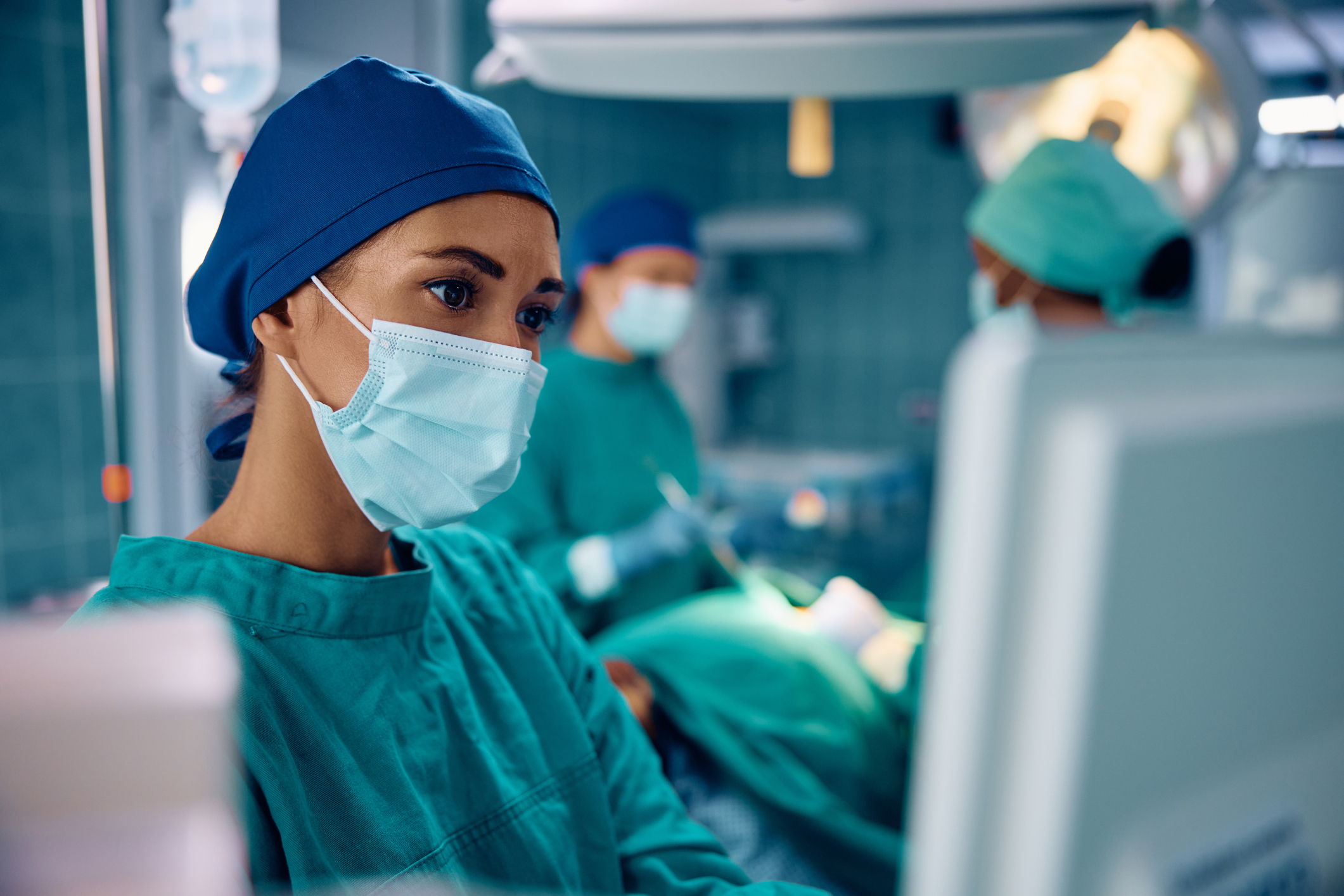 CRNA looks at a computer screen while in a surgery room