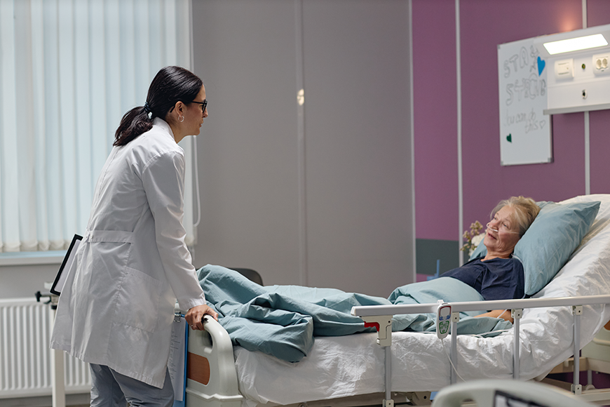Doctor with patient in hospital bed