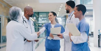 Alumna de Cibertec en formación continua en salud saluda a médicos en un hospital.