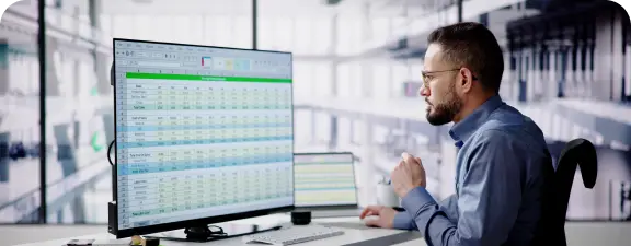 Dos ejecutivos analizan datos en Microsoft Excel, optimizando estrategias y decisiones de negocio.