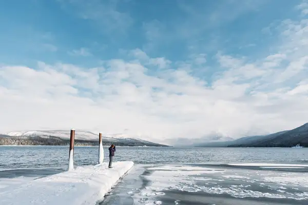 Glacier National Park - a view from St. Mary Lake in the winter, frozen over with mountains in the background.