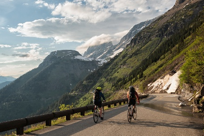 Cyclists ride along a mountain road with switchbacks in Montana’s scenic valleys and peaks