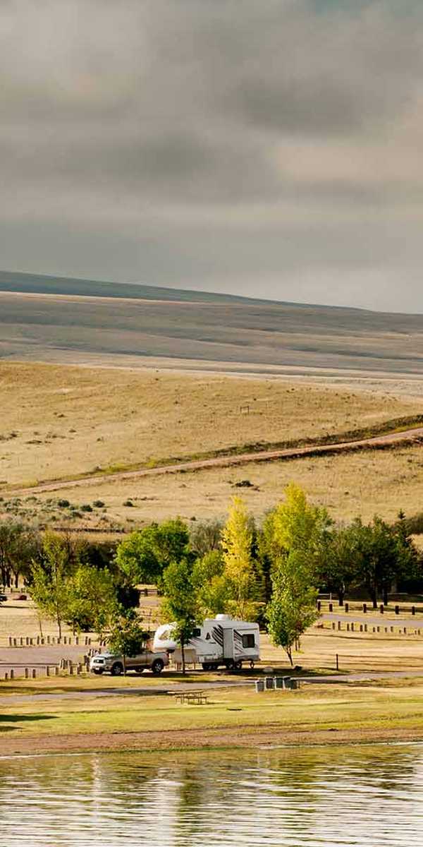 Riverside campground along the Yellowstone River with RVs and cabins in rural Montana