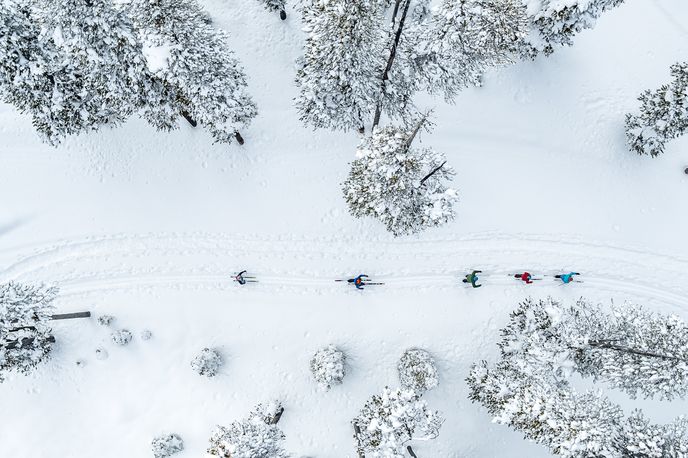Snow-covered mountain with a ski area and multiple chairlifts carrying skiers downhill in Montana