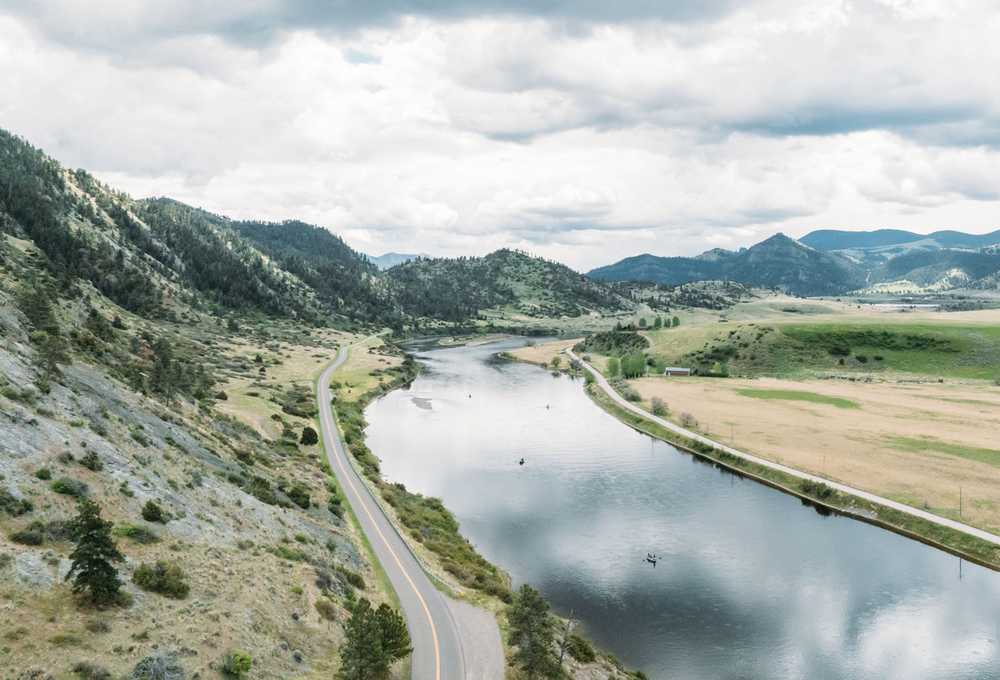 Highway along Missouri River in Wolf Creek, Montana with kayakers in river.