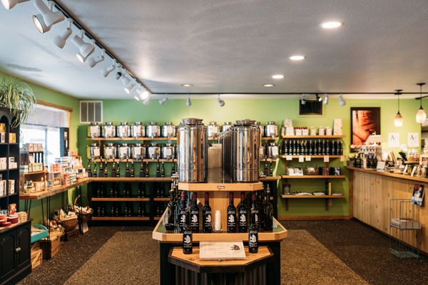 Tasting room interior with shelves of Montana beer and wine bottles and a central wooden table for sampling drinks