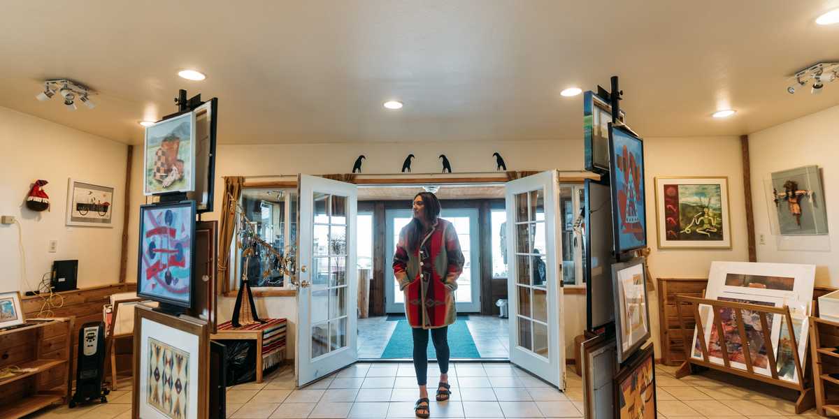 Visitor walking through the entrance of a Montana visitor center hallway with exhibit displays on both sides