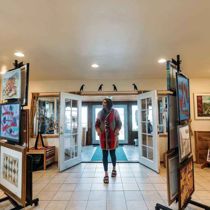 Visitor walking through the entrance of a Montana visitor center hallway with exhibit displays on both sides