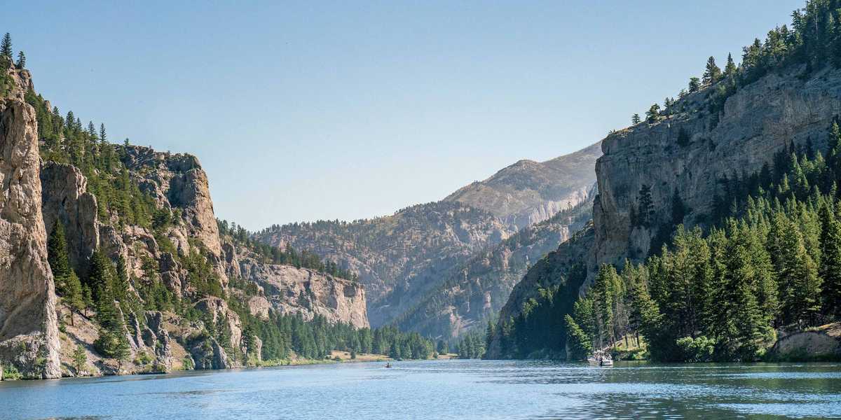 Calm mountain lake with forested cliffs in Glacier National Park, Montana