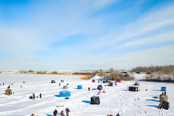 Snow-covered beach along the Missouri River with people relaxing and playing on ice during a winter day in Montana