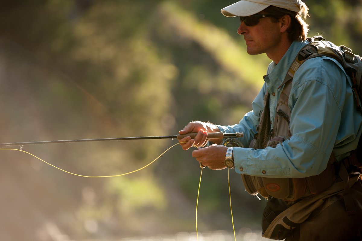 Hiker in a Montana mountain landscape setting up campsite equipment at a cable line during daytime