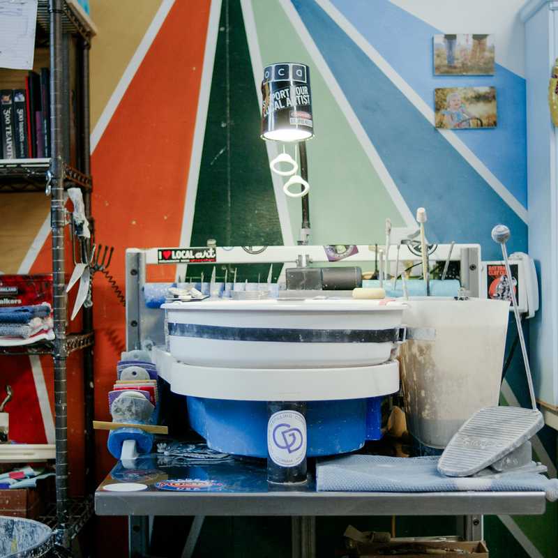 Colorful rowboat and boating supplies displayed in a shop, with shelves of books and merchandise inside