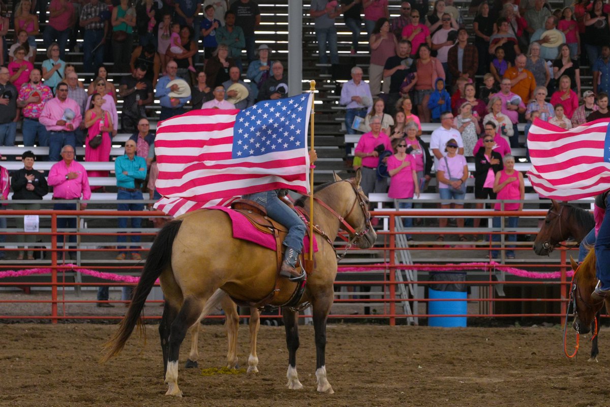 American flag held in the stands at a rodeo arena during a spectator event