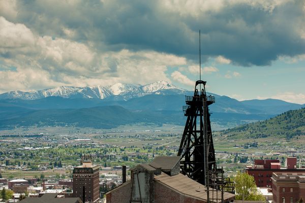 Industrial tower and city view with snow-capped mountains in the background