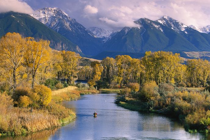 River with fall-colored cottonwoods and snowcapped mountain peaks in the background