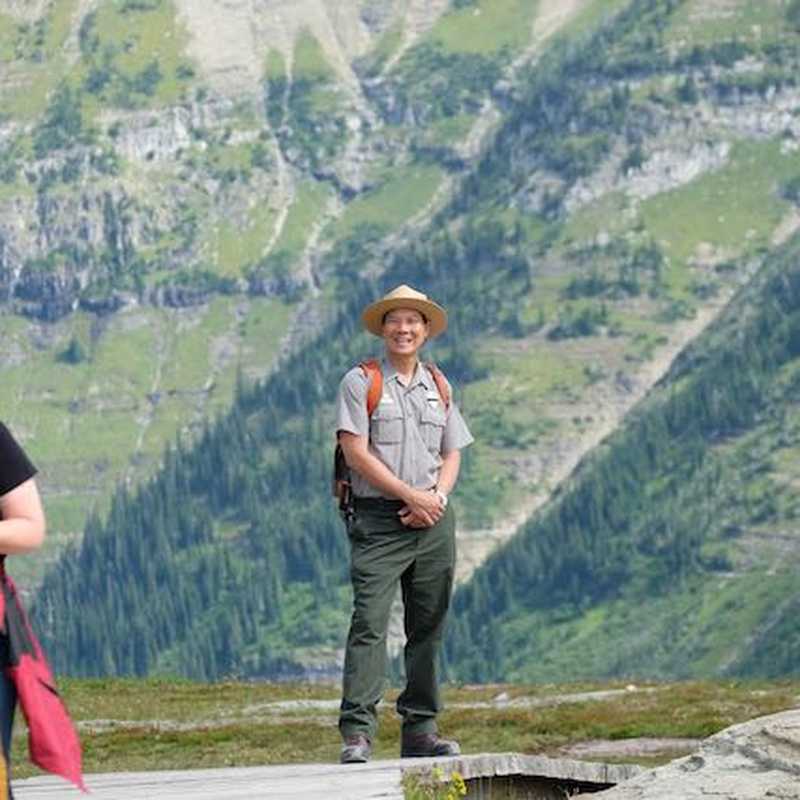 Hikers standing on a mountain overlook with a wide valley view in the background