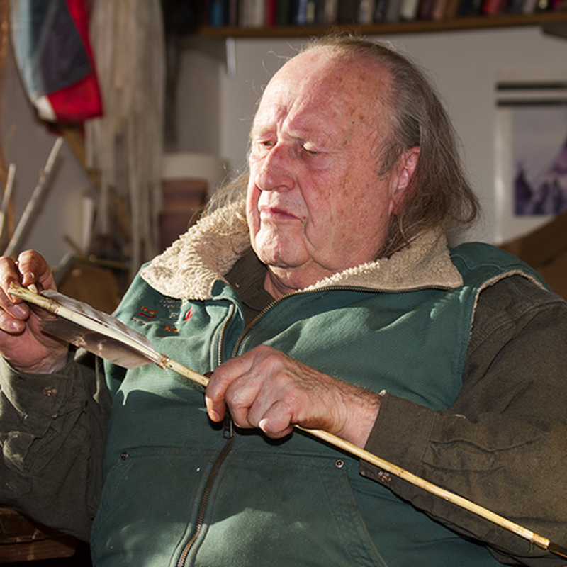 Older woman using tools to repair or work on wood in a workshop