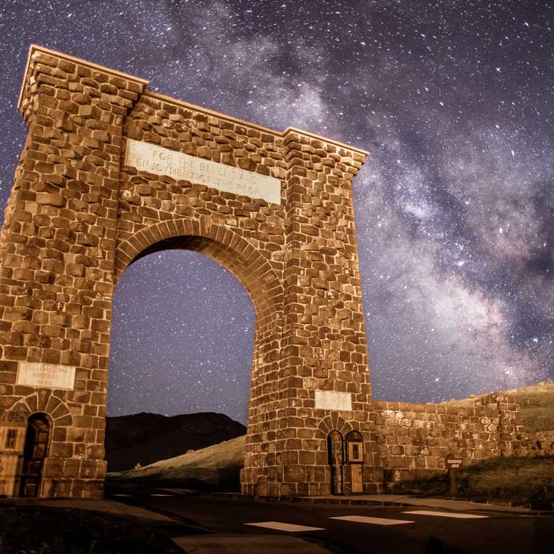 Stone archway under a starry night sky with the Milky Way visible in Montana
