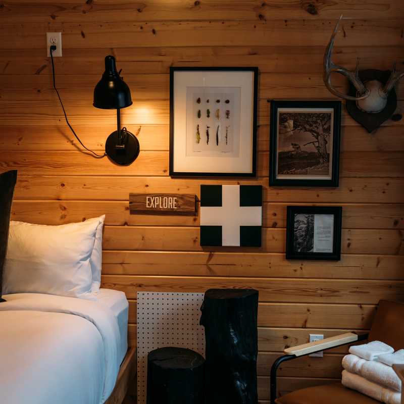 Cozy cabin bedroom with bed, wall art, and mounted light fixtures in Montana retreat setting